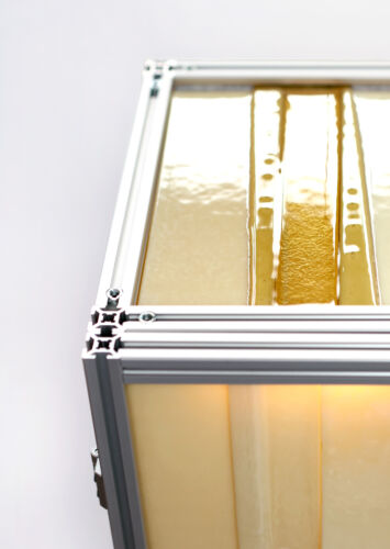 detail of butter honey yellow slumped glass cabinet with aluminium extrusion profile frame design by dutch invertuals