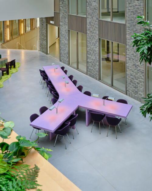 purple veneer wooden table with reading lights in coworking space by dutch invertuals
